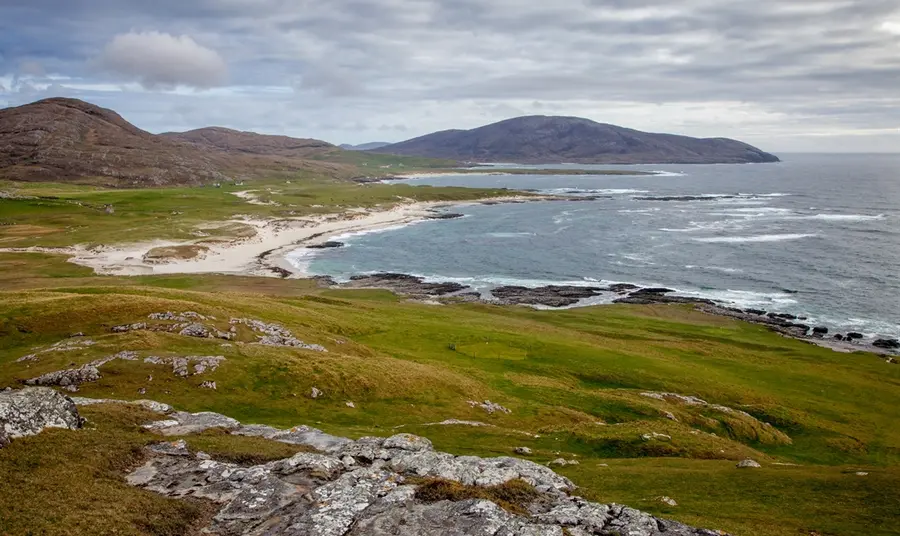 A view of Barra’s dramatic coastal landscape. A view looking along the rugged coastline of Barra, towards white sand beaches and distant hills.