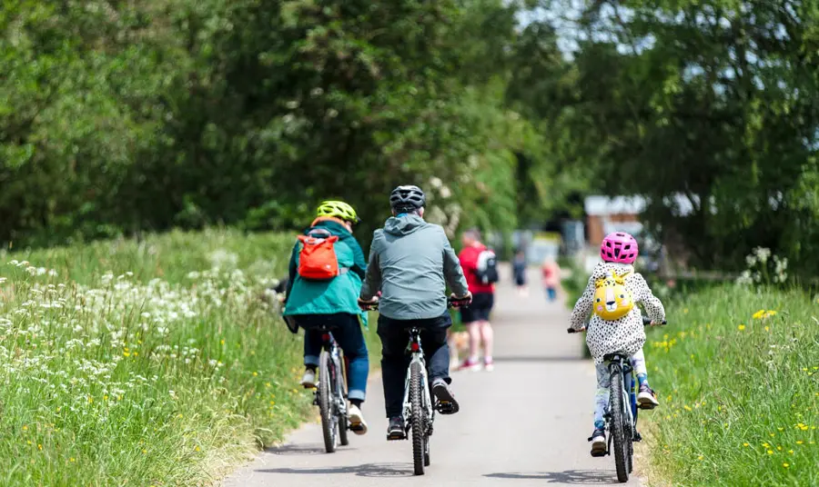 A family cycle on a road on a day out to a heritage site