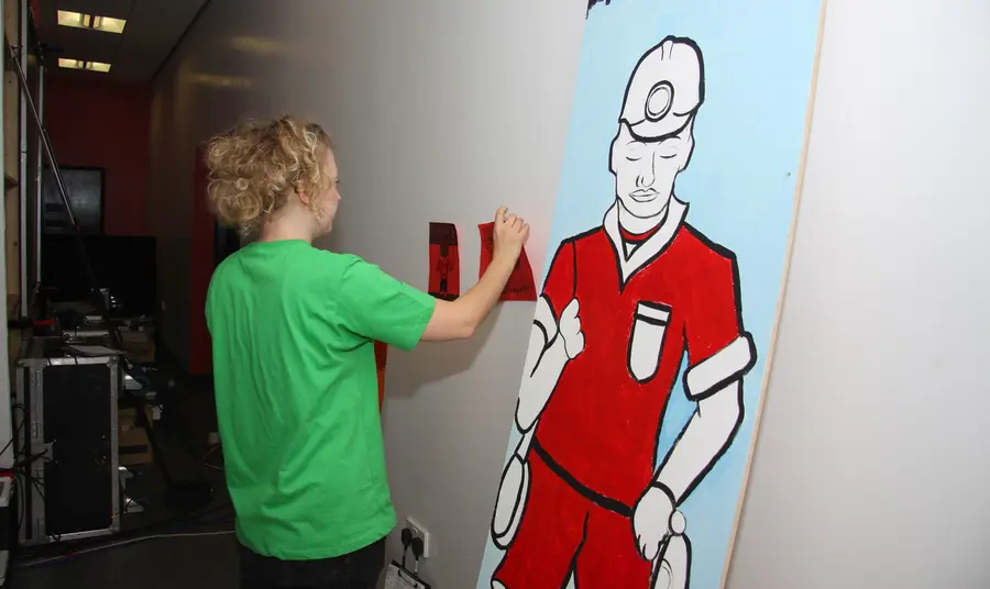 A young person setting up an exhibition for the From Coal to Goal project