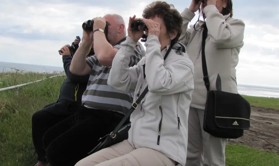 Participants of the Following Fred project using binoculars