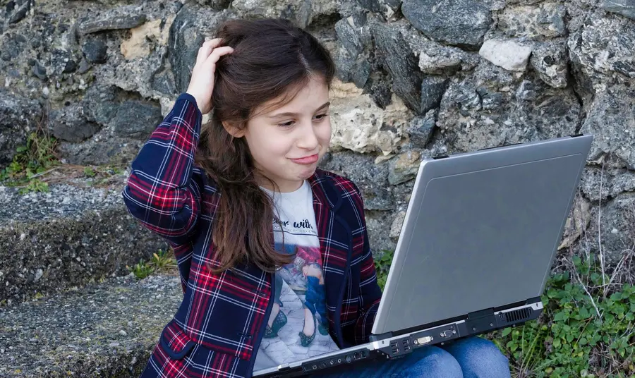 Digital guide: working safely online with children and young people Young person looking at phone on beach