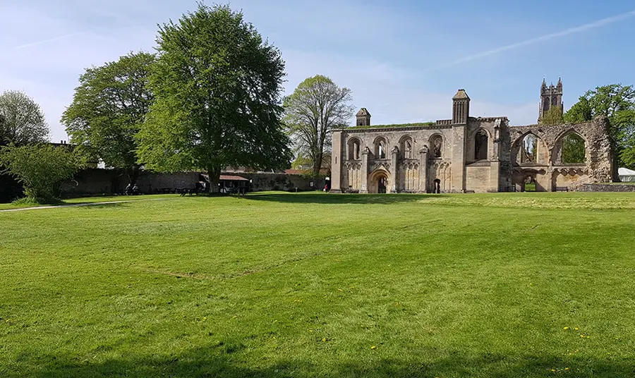 Glastonbury Abbey reopens thanks to emergency funding Glastonbury Abbey with a lawn foregrounded