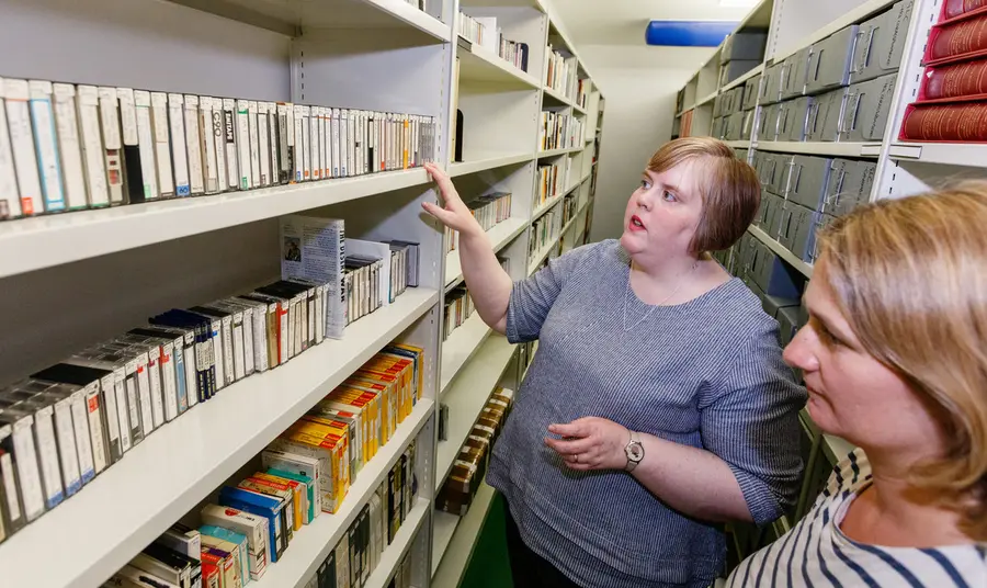 Digitising the legacy of disability champion Leonard Cheshire Two people looking at tapes on shelves