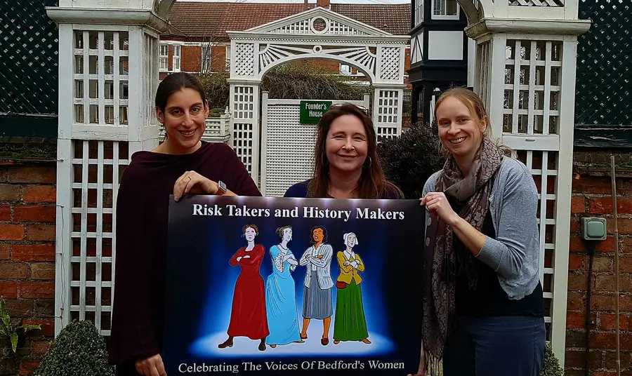 Risk Takers and History Makers - Celebrating the voices of the Women of Bedford Women holding a sign