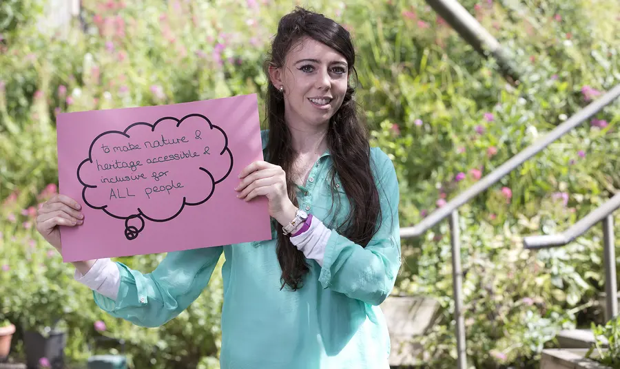 How do we involve young people in nature? Young woman holding sign