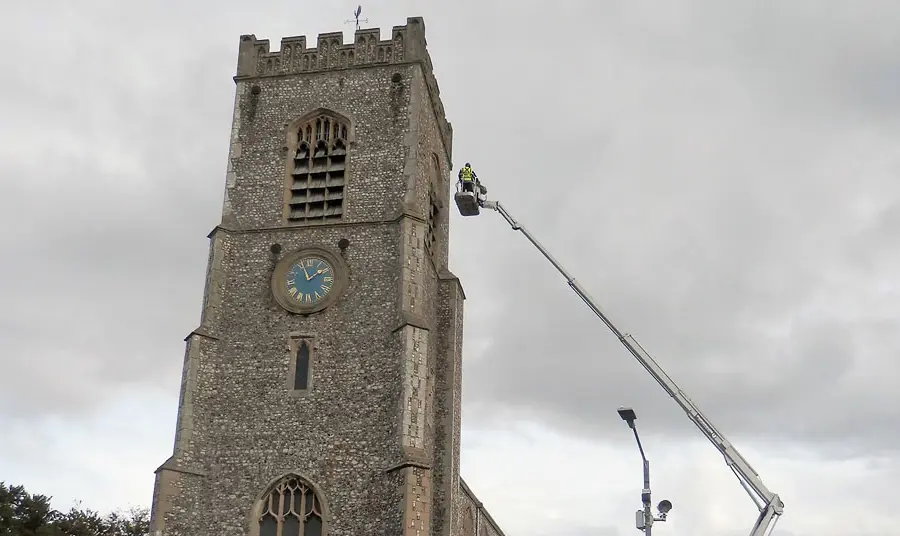 Architectural assessment of the tower at St Nicholas Church The tower of St Nicholas with a person on a crane assessing the tower roof