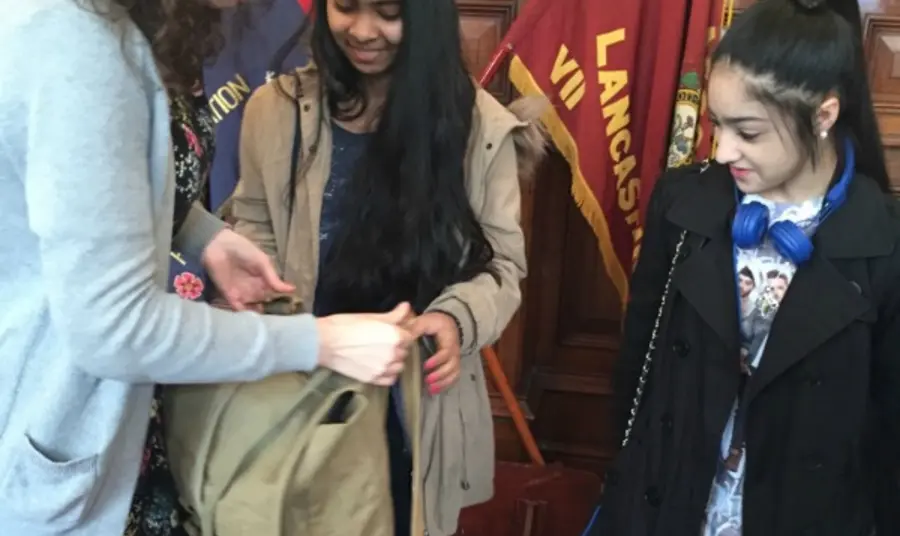 Young people look at army bag