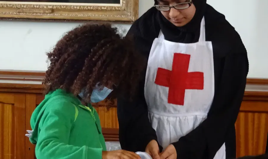 Wartime medicine and innovation A young participant demonstrates wartime medical techniques to a young visitor