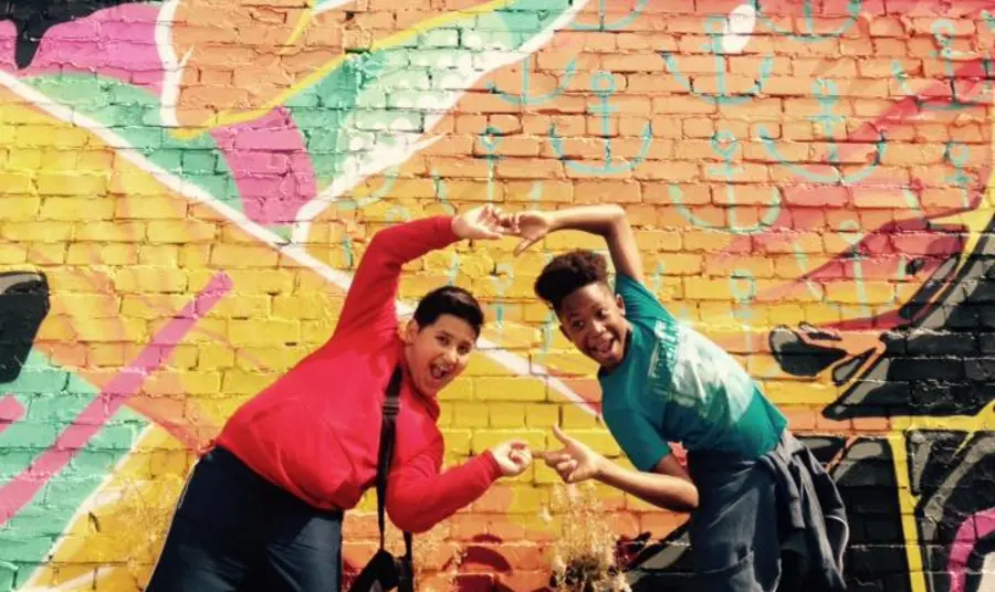 Our Musical Roots Young people pose by graffiti art