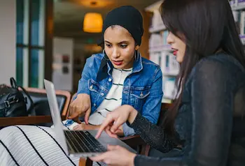 Two people looking at a laptop