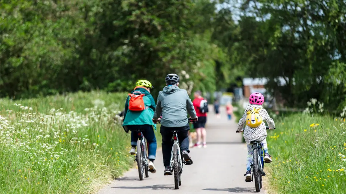 Arriving by bike at National Trust property Belton A family cycle on a road on a day out to a heritage site