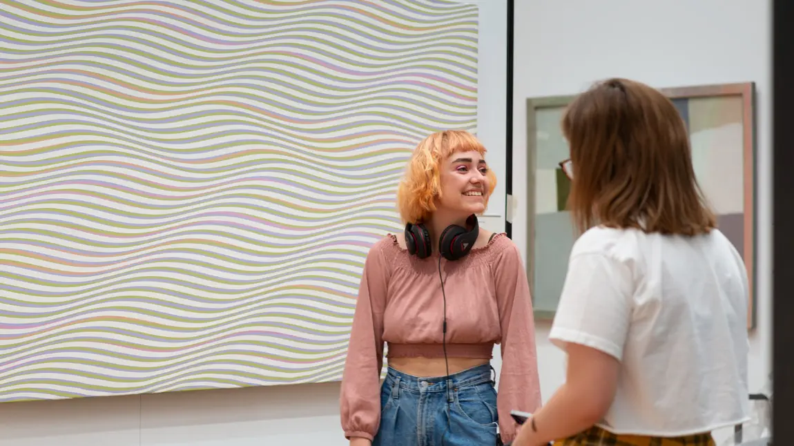 Transformed home for one of the UK’s finest art collections Two Gallery visitors in front of a Bridget Riley patterned painting