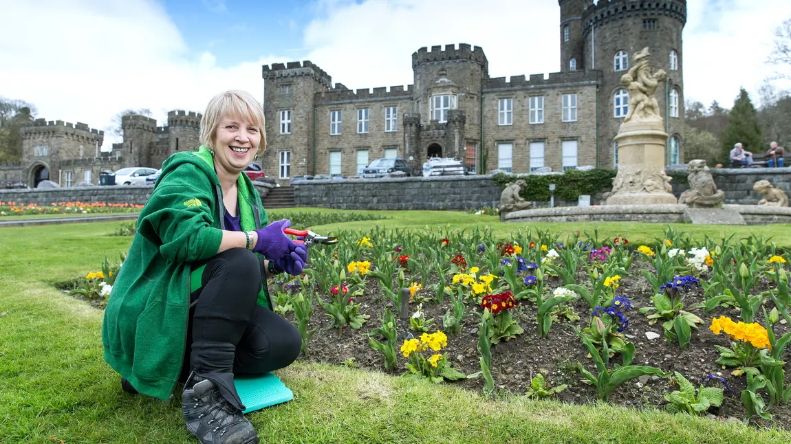 Changing lives: Angela's root to recovery Woman crouching in grounds of a castle