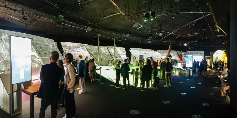 People looking at exhibition inside large building